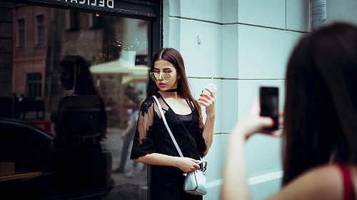 people woman taking photo of woman carrying sling bag person