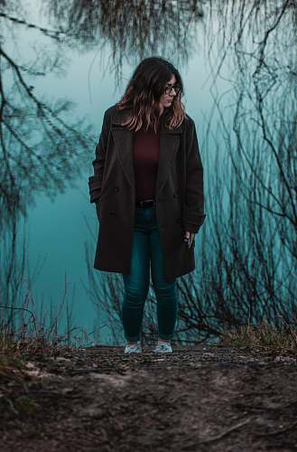 person woman walking near withered plants people