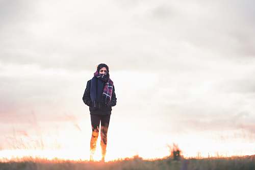 people woman walking on green grass under cloudy sky at daytime person