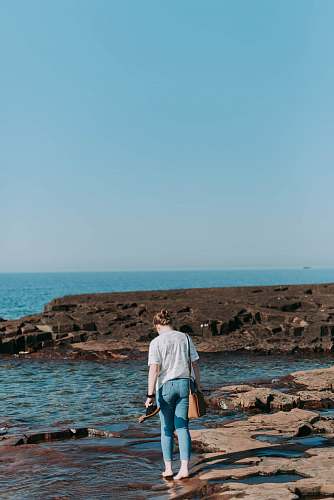 people woman walking on shore by the sea person