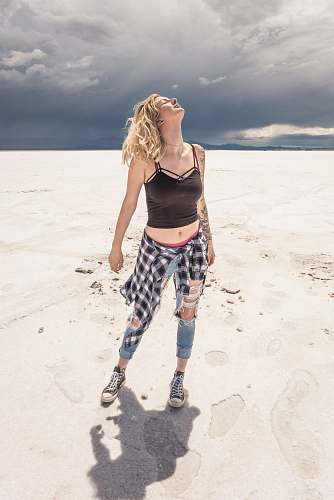 person woman wearing black crop top standing on desert people