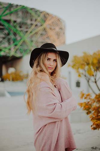 people woman wearing black hat and pink dress person