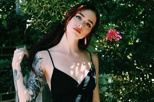 person woman wearing black top standing near flower people