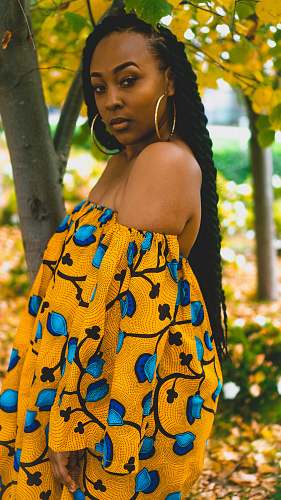 person woman wearing off-shoulder dress standing near tree people