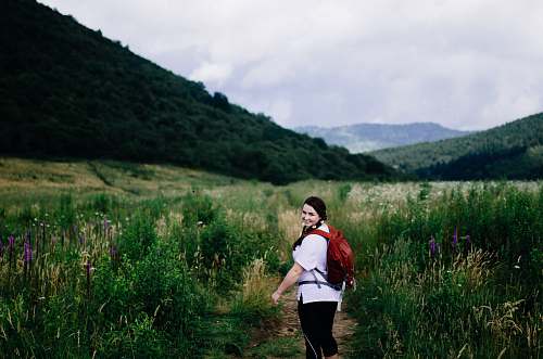 person woman wearing red backpack surrounded plants people