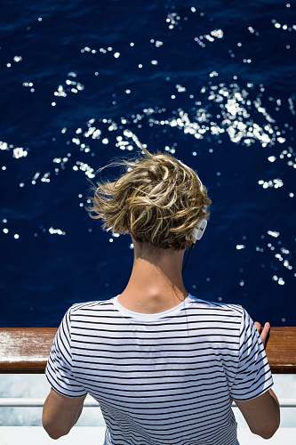 person woman wearing white and black striped shirt looking at water people