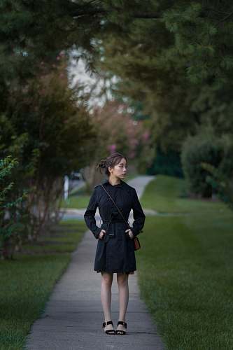 people women's black dress shirt standing on pathway person