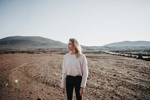 people women's white crew-neck long-sleeved shirt, black pants, and silver-colored hoop earrings person