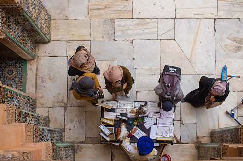 human aerial view photography of people in front of man sitting next to brown wooden table person