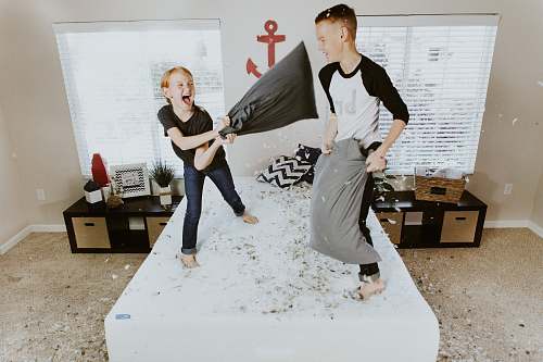 human boy and girl having pillow fight person