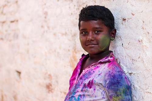 human boy leaning on white wall at daytime person