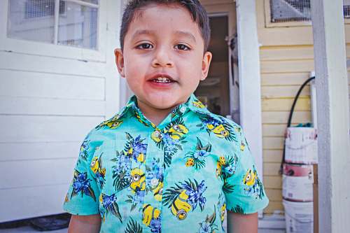 person boy wearing multicolored floral button-up shirt human
