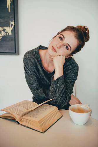 human brown-haired woman in black sweater near brown book person
