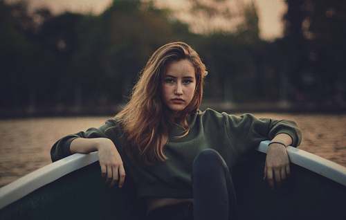 human closeup photography of woman wears green sweater on boat person