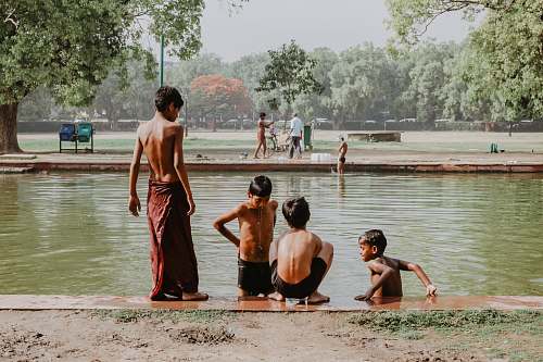 human four toddlers standing near body of water person
