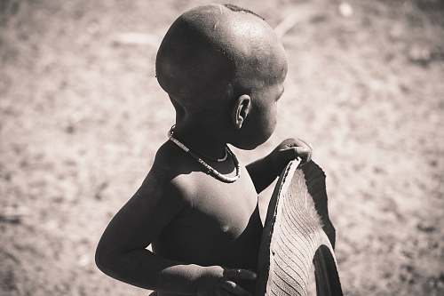 human grayscale focus photo of children holding tire person