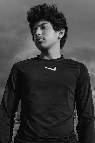 person grayscale photo of man wearing Nike shirt black-and-white