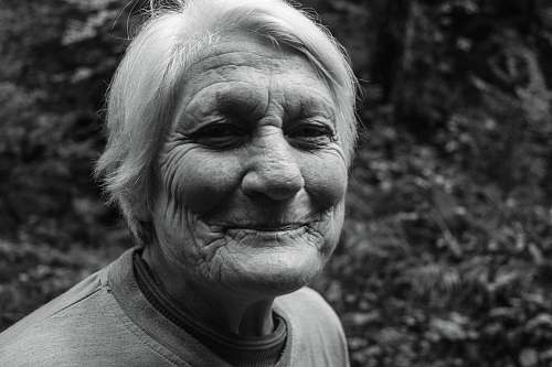 black-and-white grayscale photo of smiling woman in crew-neck T-shirt face