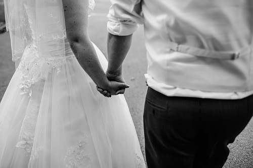 human grayscale photo of wedded couple holding hands black-and-white