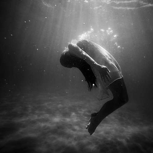 black-and-white grayscale photo of woman drowning in water grey