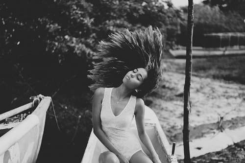 black-and-white grayscale photo of woman wearing sleeveless dress boat