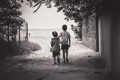 human grayscale photography of child and toddler while walking grey