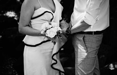 person grayscale photography of man and woman holding hand together black-and-white