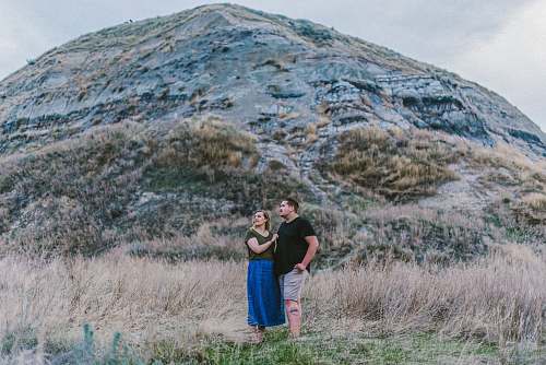 human man and woman standing near mountain person