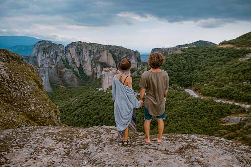 outdoors man and woman standing on the cliff rock