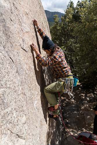 person man climbing on rock during daytime human