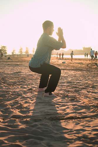 human man closing his hands white squatting on sand person