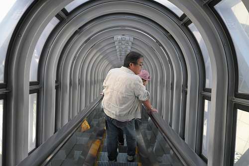 human man holding baby riding escalator person