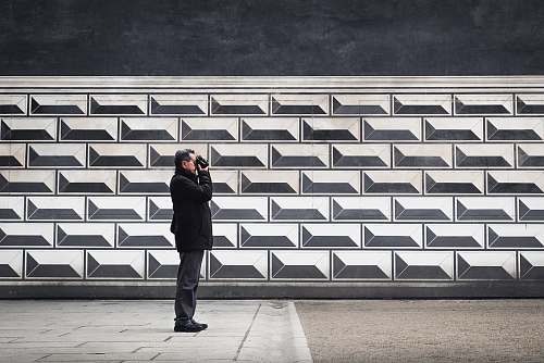 human man holding camera near wall person