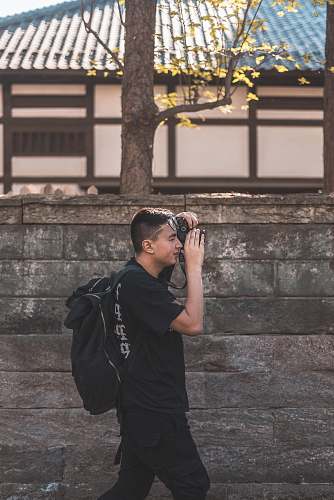 person man holding DSLR camera taking picture human