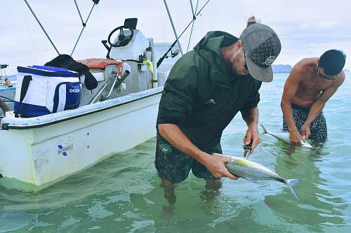 person man holding fish boat