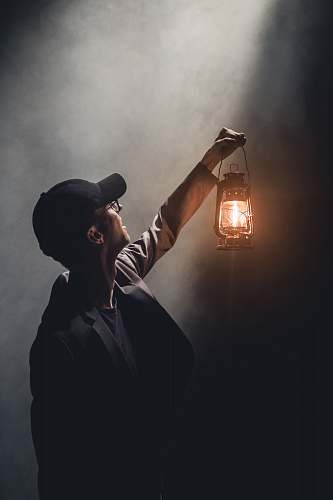 human man holding lighted gas lantern person