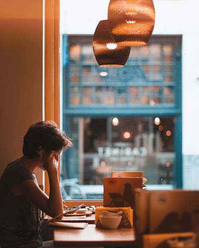human man holding on tablet while sitting on chair in restaurant person