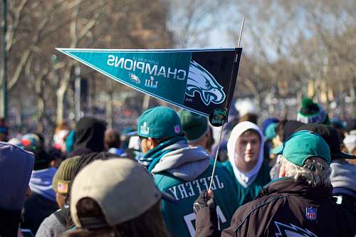 person man holding Philadelphia Eagle pennant crowd