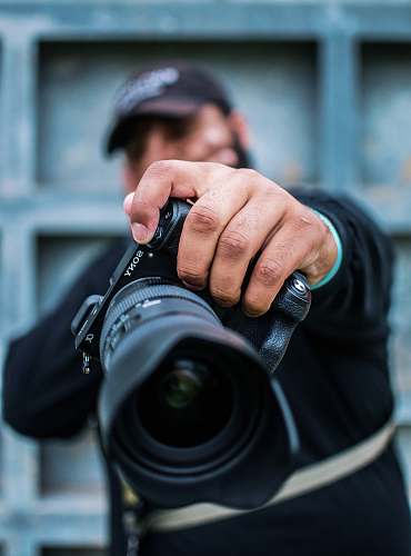 person man holding Sony DSLR camera photographer