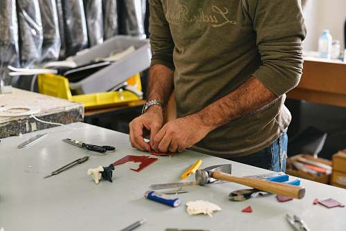 person man holding tool in front of table work