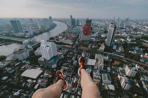 person man paragliding taking aerial photography of city scapes during daytime city