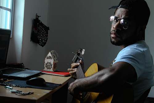 human man playing guitar beside table person