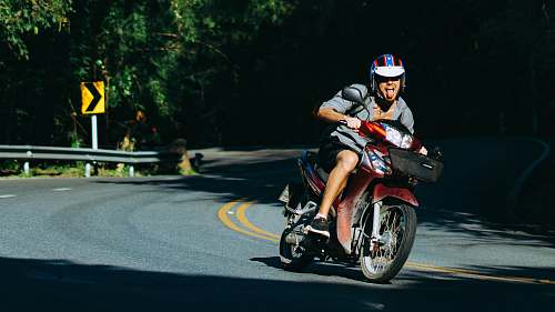 human man riding motorcycle on curved road motorcycle