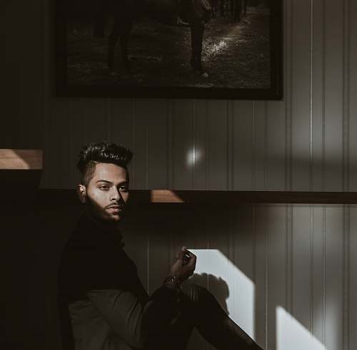 human man sitting beside painting person