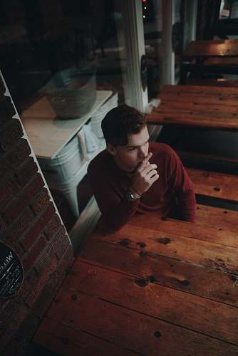 human man sitting on brown wooden bench person