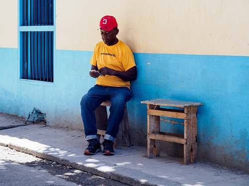 person man sitting on brown wooden stool whole holding banknote human