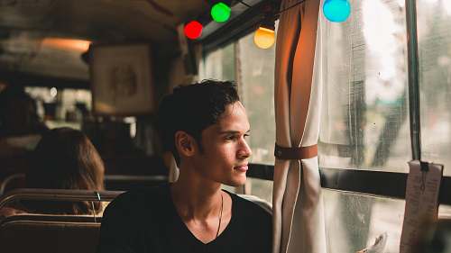 human man sitting on chair looking near window person