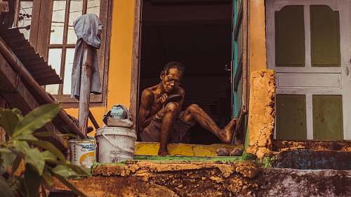 human man sitting on door frame person
