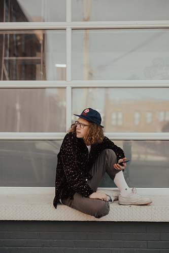 person man sitting on metal surface looking at his left human