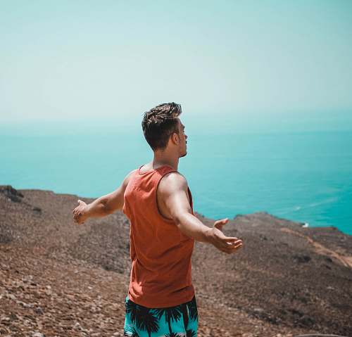 person man spreading his arms on top of mountain human